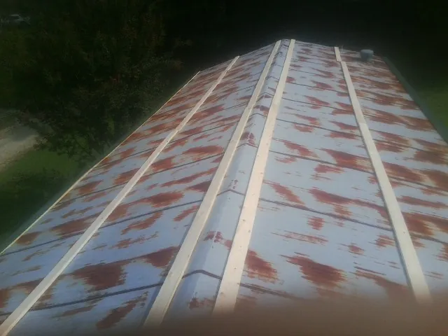 Rusted metal roof panels with new wood purlins before replacement — Storm Damage Roof Repair in Taylorville by Roofing Brothers