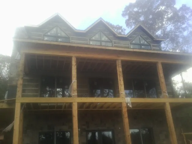 Dormers and porch framing on a large log home under construction — Roof Coating work by our crew in Taylorville