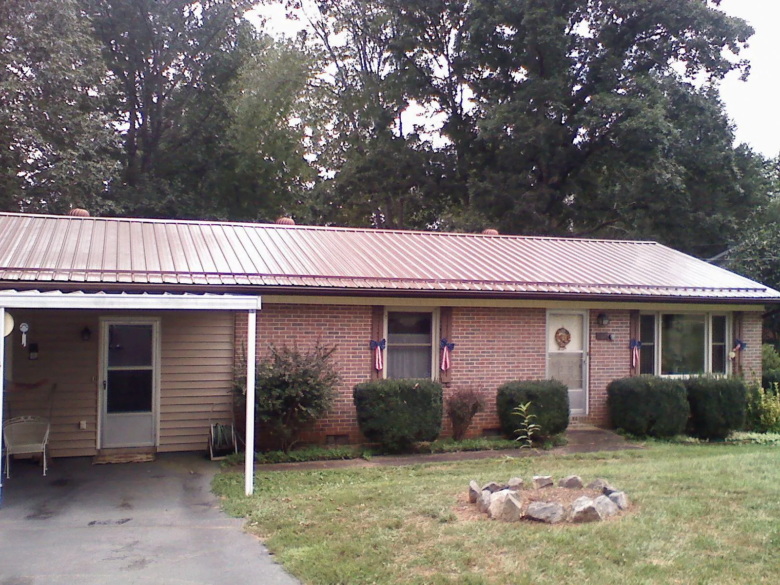 Bronze metal roof and carport on a brick ranch home — Roof Repair work by our crew in Taylorville